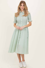 woman wearing a green gingham shirt dress with button detail and short sleeves, paired with white sneakers