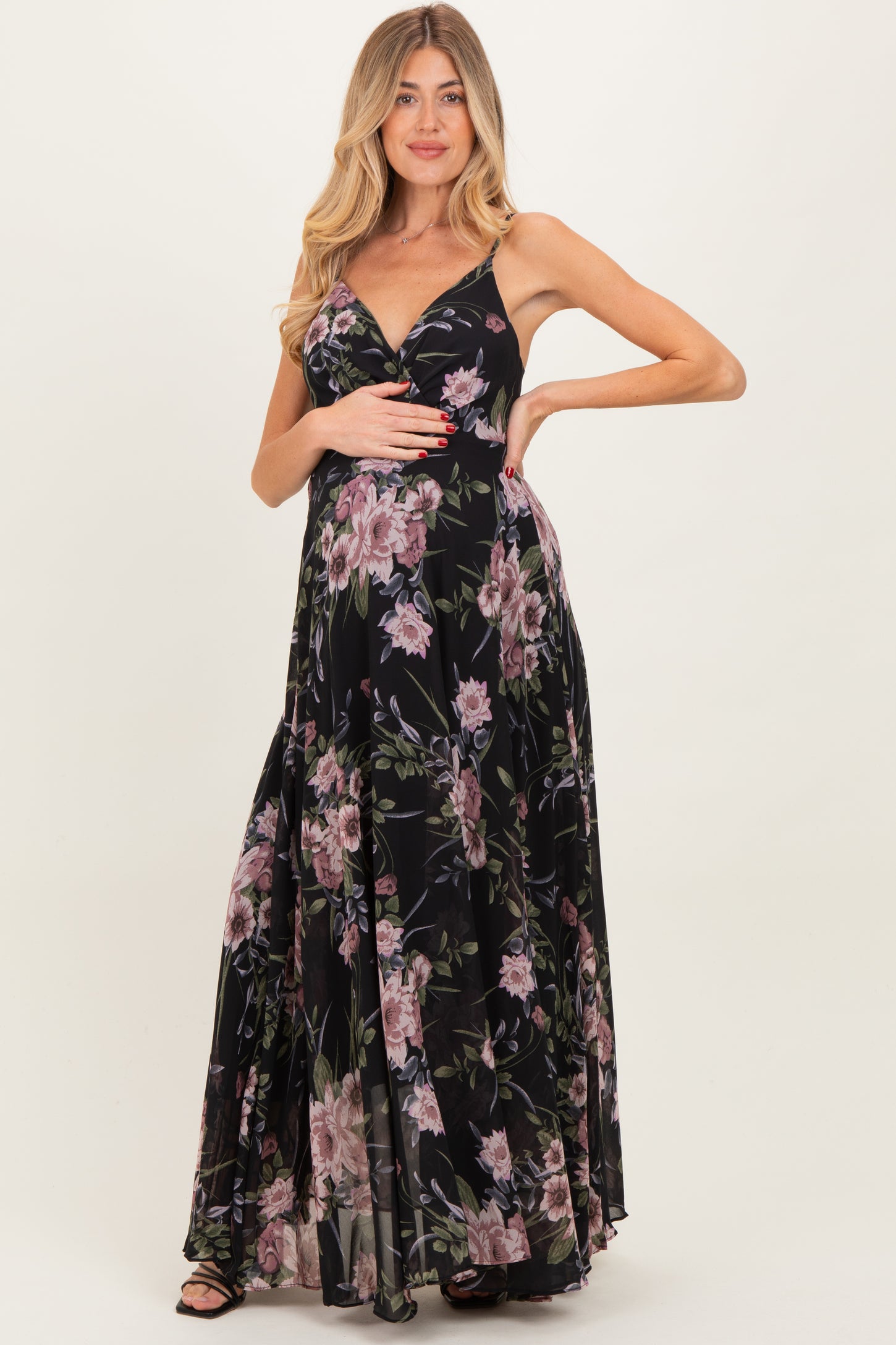 woman wearing a floral black maternity maxi dress and holding her baby bump