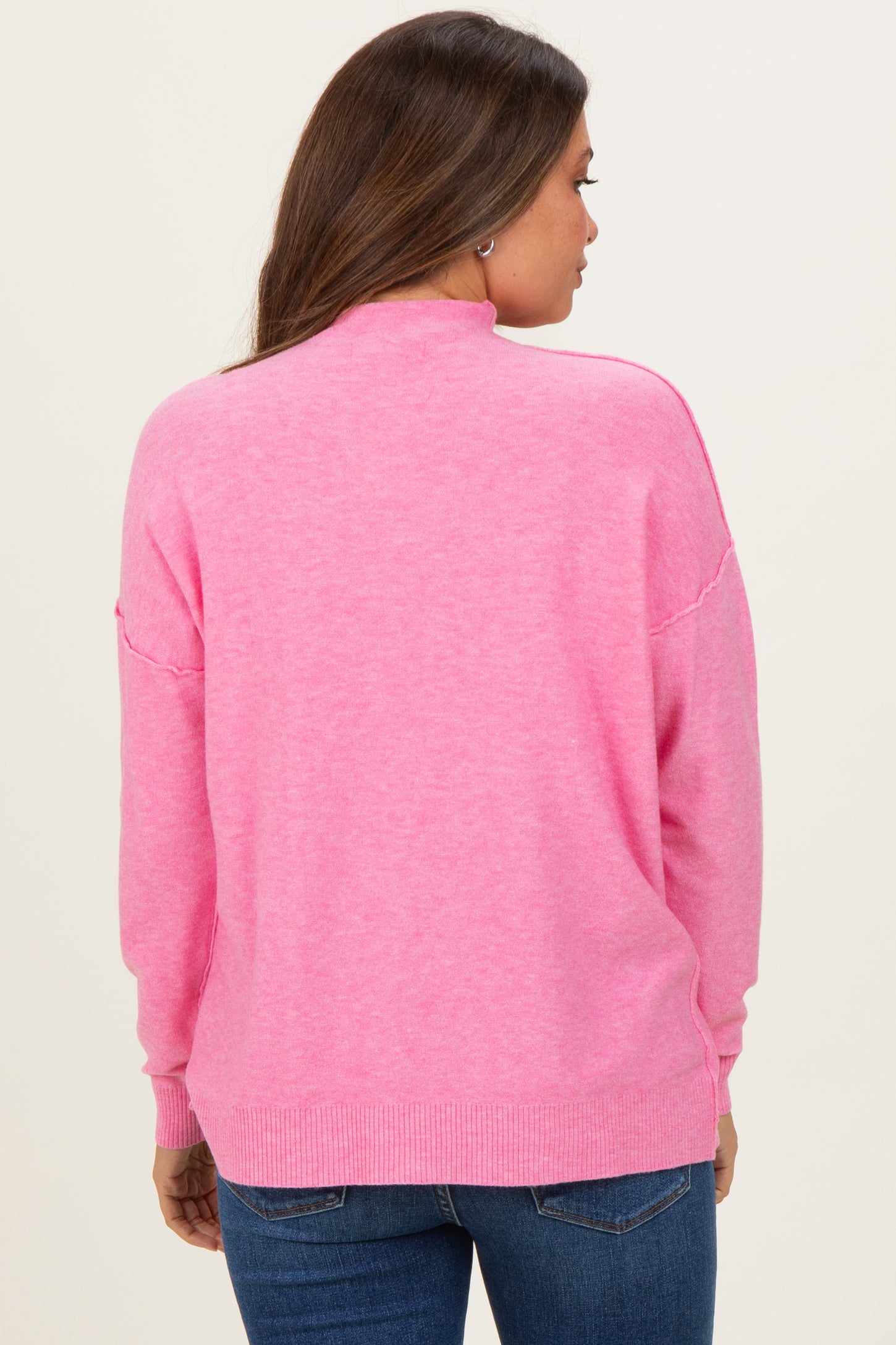 woman wearing a pink maternity sweater with a relaxed fit and ribbed hem, view from the back
