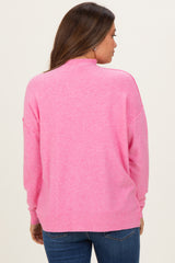 woman wearing a pink maternity sweater with a relaxed fit and ribbed hem, view from the back