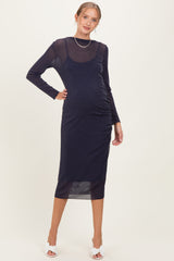 woman wearing a navy long sleeve maternity dress with ruched sides and a fitted silhouette, showcasing her baby bump