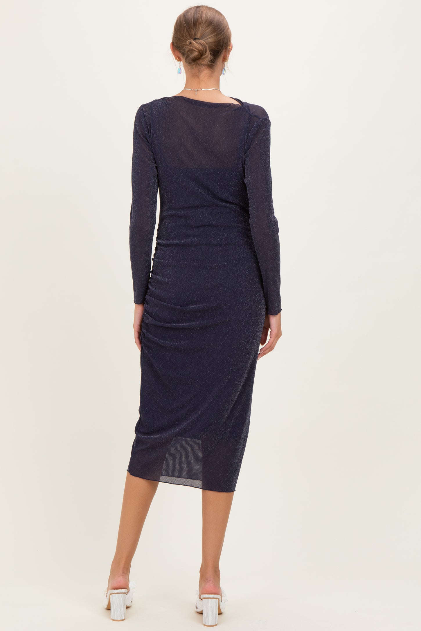 woman wearing a navy blue long sleeve maternity dress with a fitted silhouette and mid-length hem