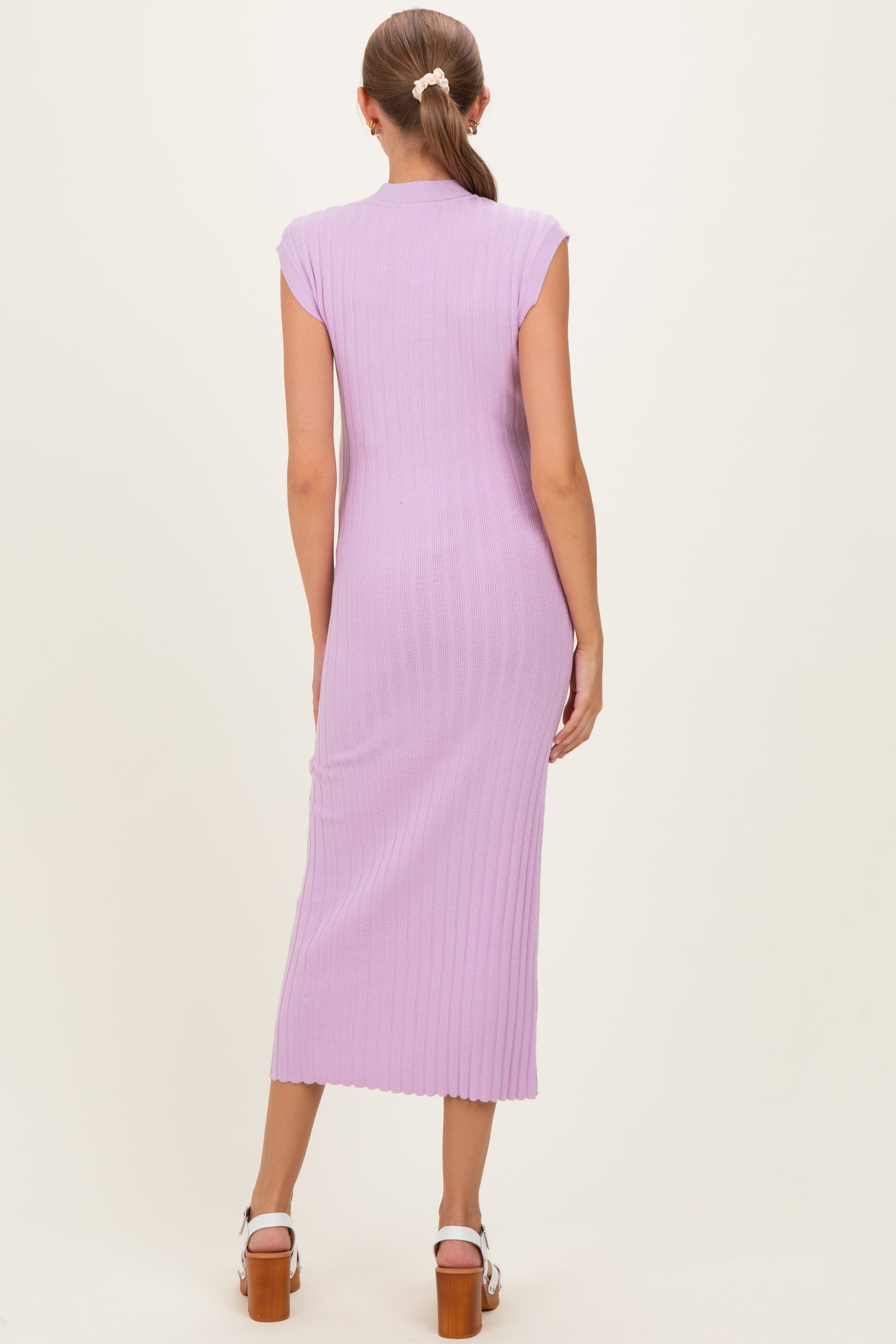 woman wearing a lavender ribbed knit maternity dress with cap sleeves, showing a fitted silhouette and mid-calf length