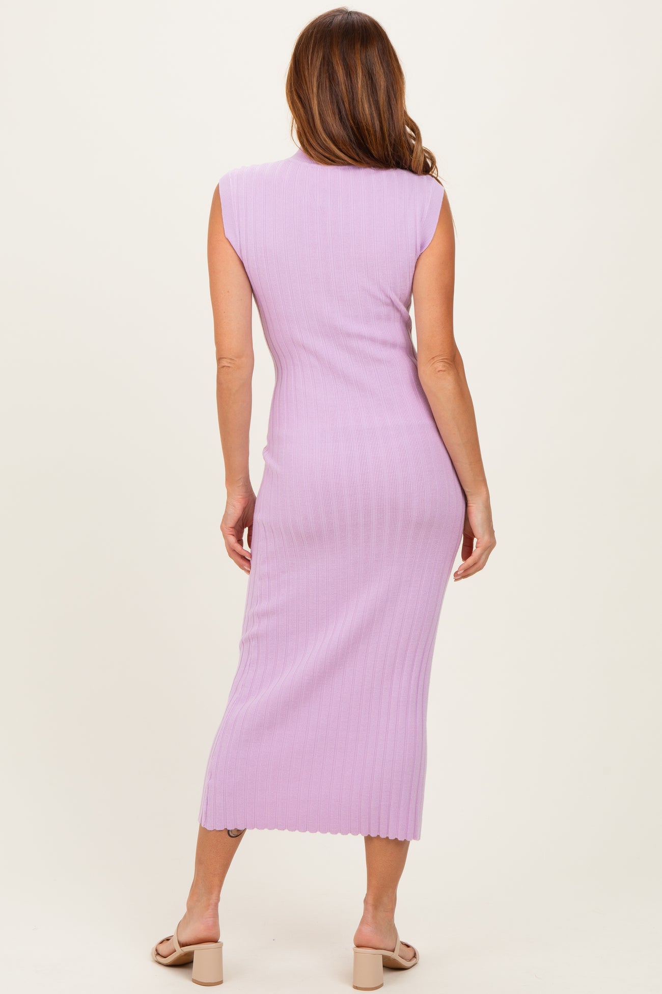 woman wearing a lavender ribbed midi dress with cap sleeves, showing the back view and long length