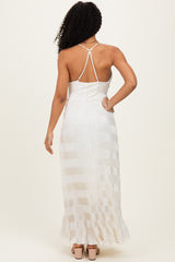 woman wearing a white pleated maxi dress with a strappy back and a flowing hem