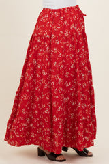 woman wearing a red floral maternity maxi skirt with a tiered design and side tie detail