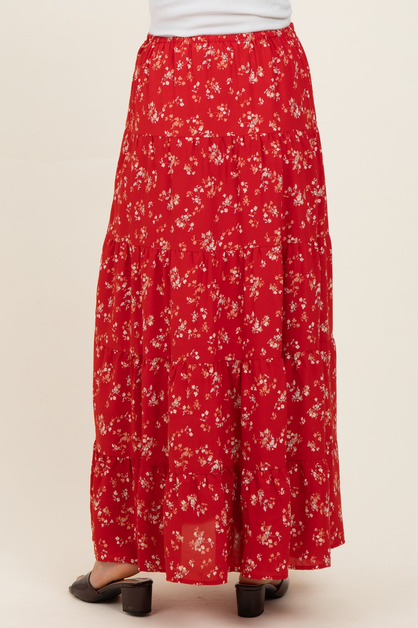 maternity wear red floral maxi skirt with tiered design, model seen from the back, wearing comfortable sandals