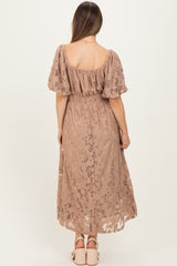 woman wearing a dusty rose maternity dress with puff sleeves and a gathered waist, showing an elegant lace design