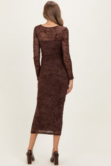 woman wearing a brown floral embroidered maternity dress with long sleeves and a fitted silhouette