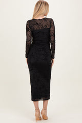 woman wearing a black long sleeve fitted dress with floral lace details, shown from the back