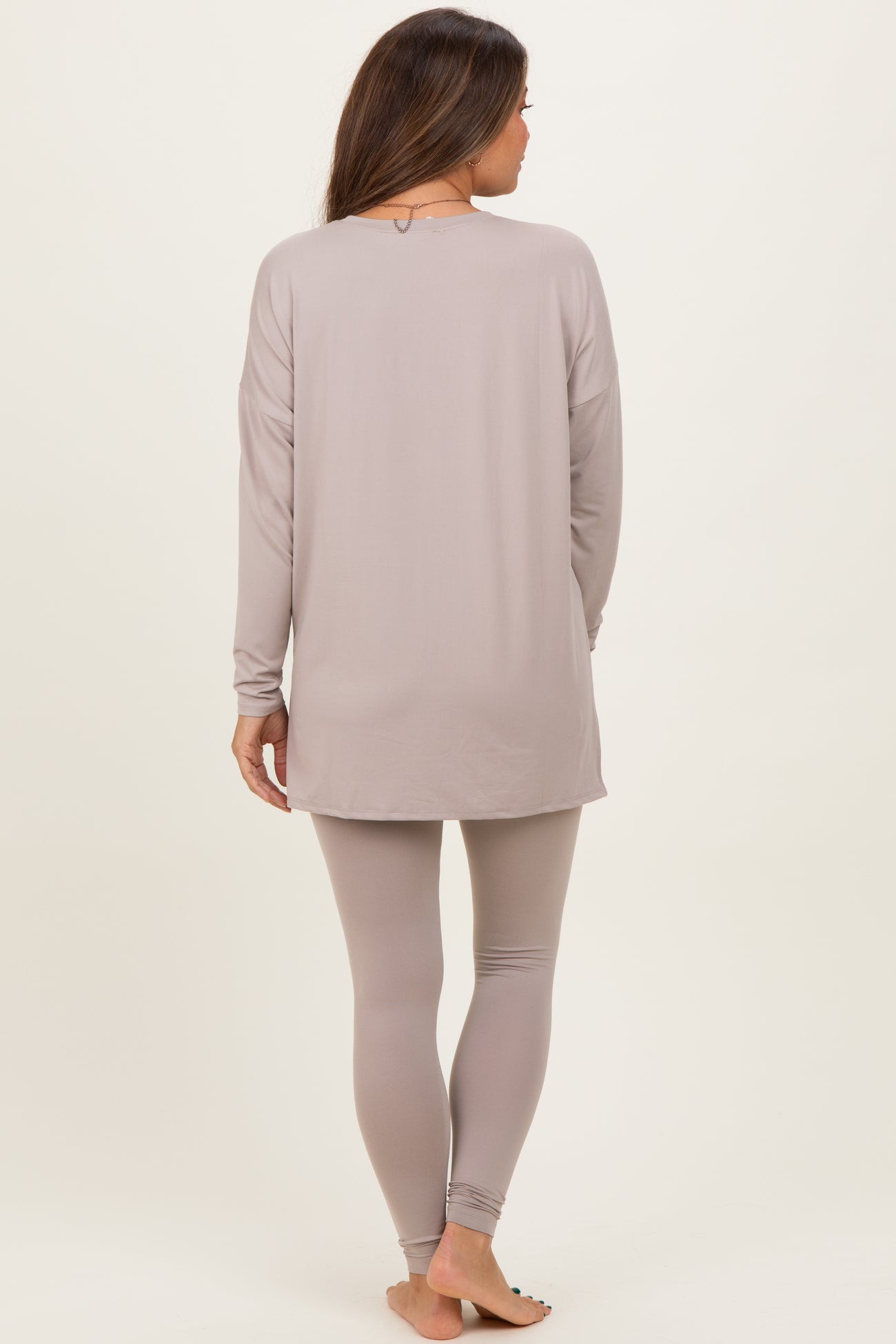 woman wearing a light gray long sleeve maternity top and matching leggings, showing a comfortable and relaxed fit from the back
