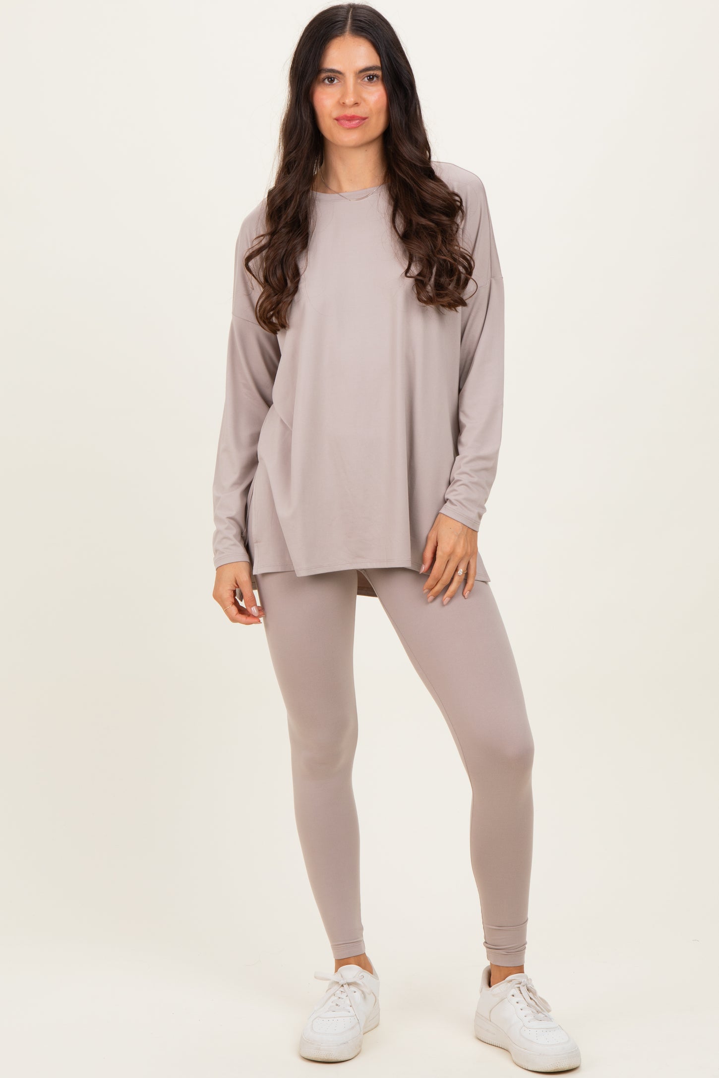 woman wearing a light taupe long sleeve top and matching leggings with white sneakers