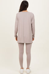 woman wearing a long sleeve taupe tunic top and matching leggings, paired with white sneakers, standing with back to the camera