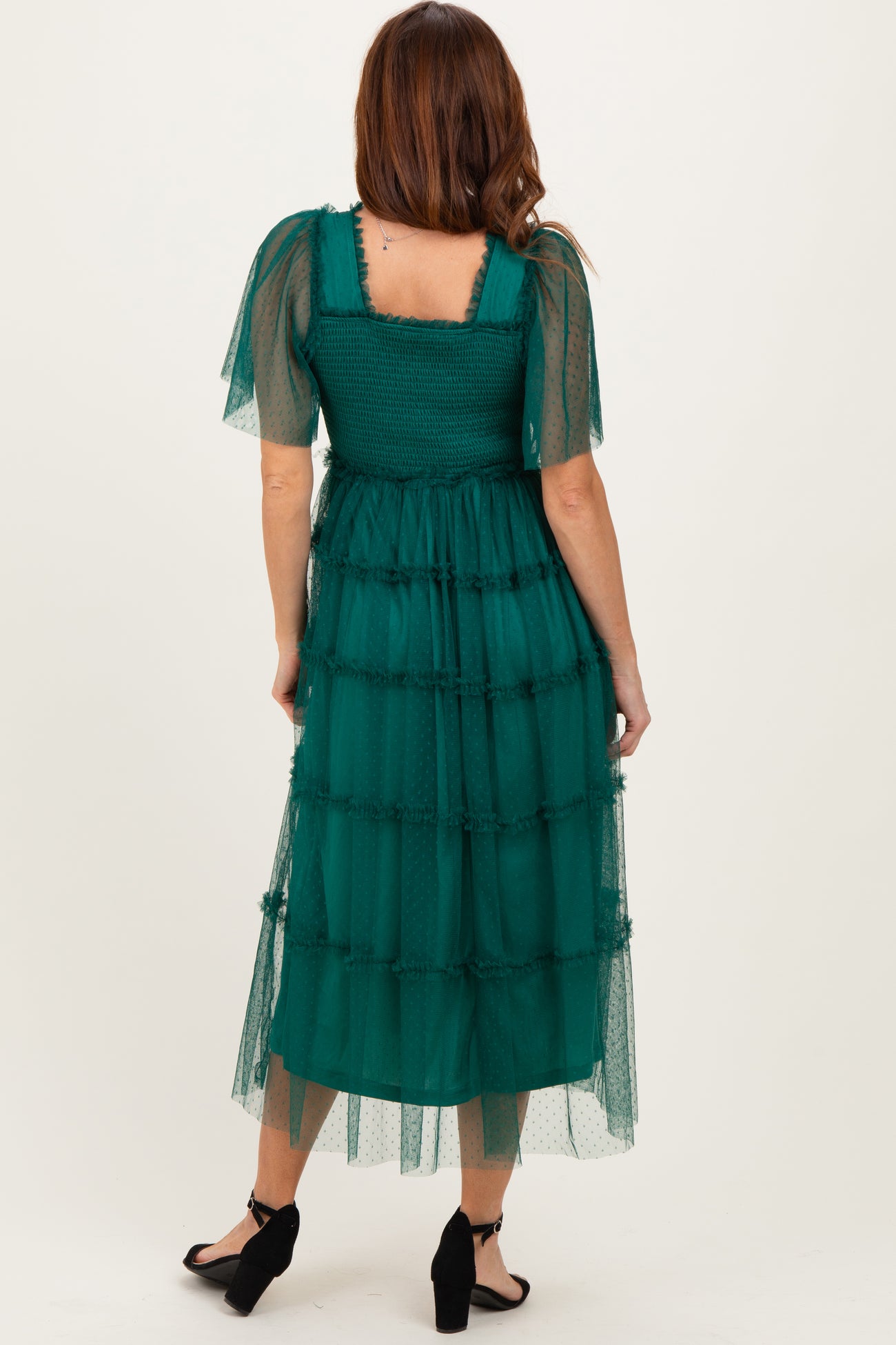 woman wearing a teal tiered midi dress with sheer puff sleeves and a square neckline seen from the back