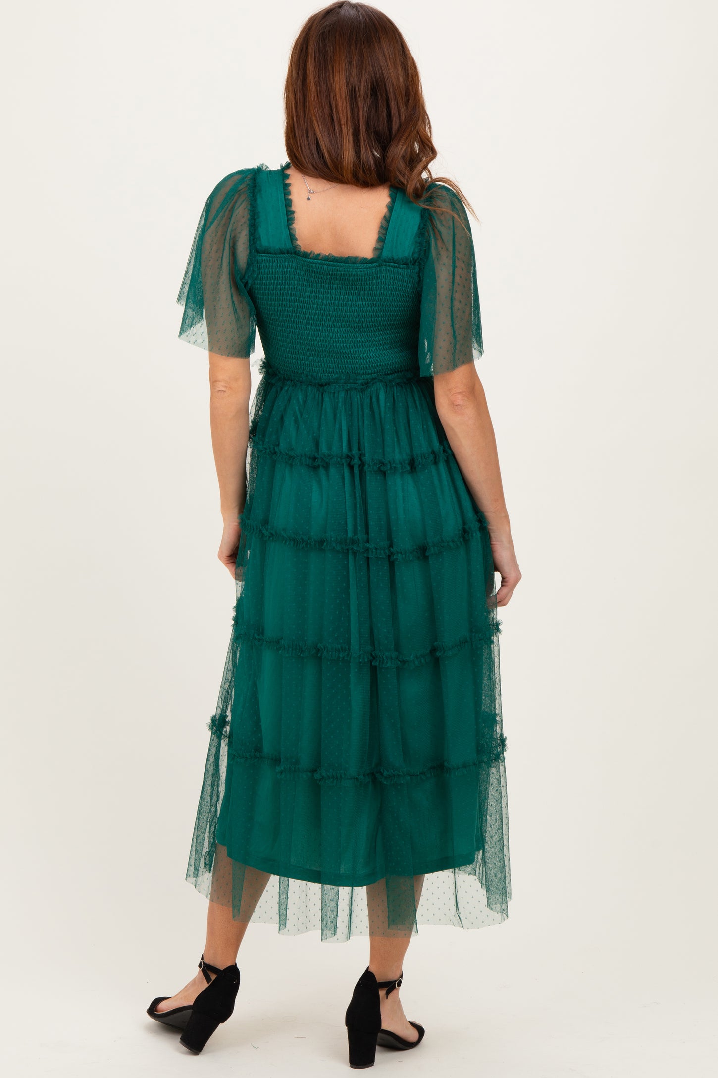 woman wearing a teal tiered midi dress with sheer puff sleeves and a square neckline seen from the back