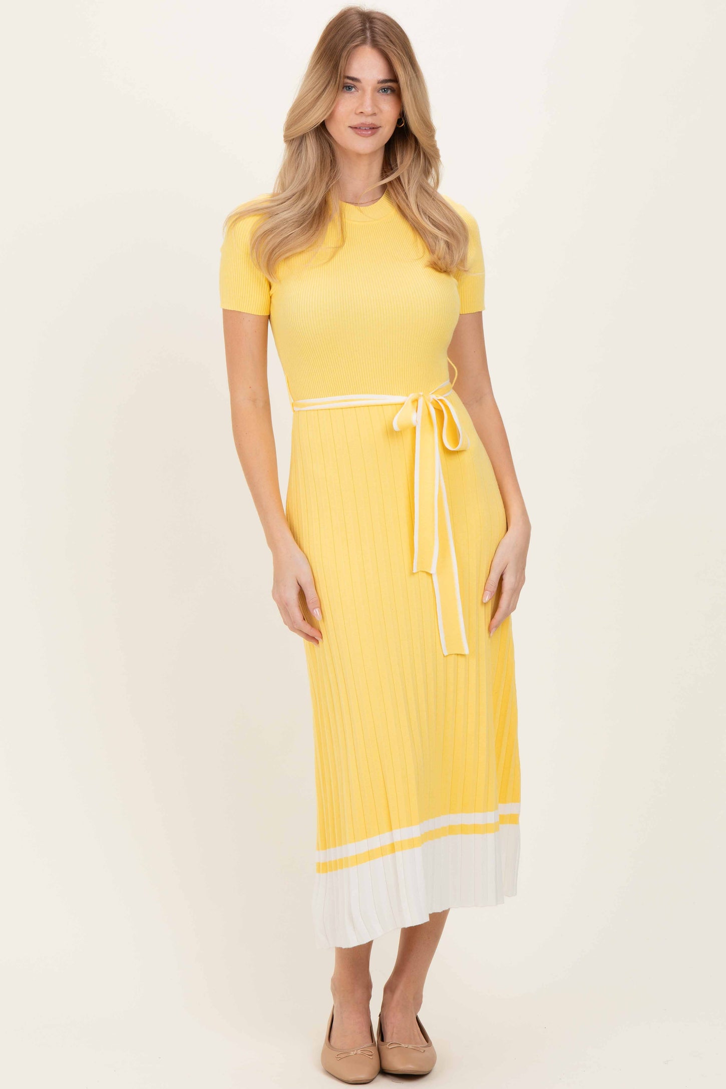 woman wearing a yellow ribbed midi dress with short sleeves and a tied waist detail