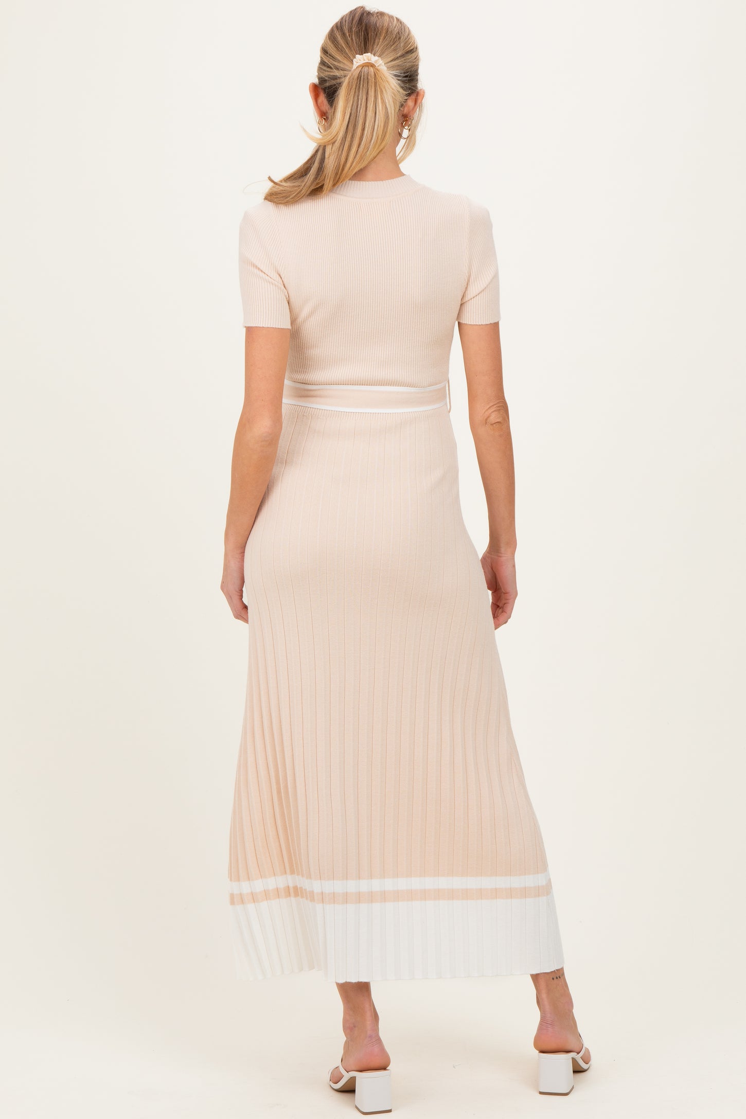 woman wearing a peach ribbed maternity maxi dress with a slim fit and short sleeves, shown from the back