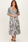 woman wearing a black and white paisley print maxi dress with a deep v-neck and tiered skirt