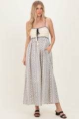 woman wearing a striped maxi dress with a crochet bodice and adjustable straps