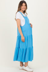 woman wearing a blue maternity maxi dress with tiered hem and a visible baby bump