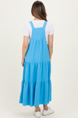 woman wearing a blue tiered maternity maxi dress with adjustable shoulder straps and a relaxed fit from the back