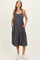 woman wearing a dark gray maternity midi dress with button details and pockets, displaying her baby bump