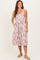 woman wearing a floral midi dress with a button front and pockets, styled with a relaxed fit and thin straps