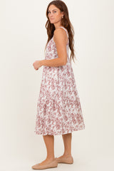 woman wearing a pink and white floral midi dress with adjustable straps and a flowy silhouette