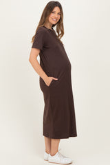 woman wearing a brown short sleeve maternity dress with pockets and a visible baby bump