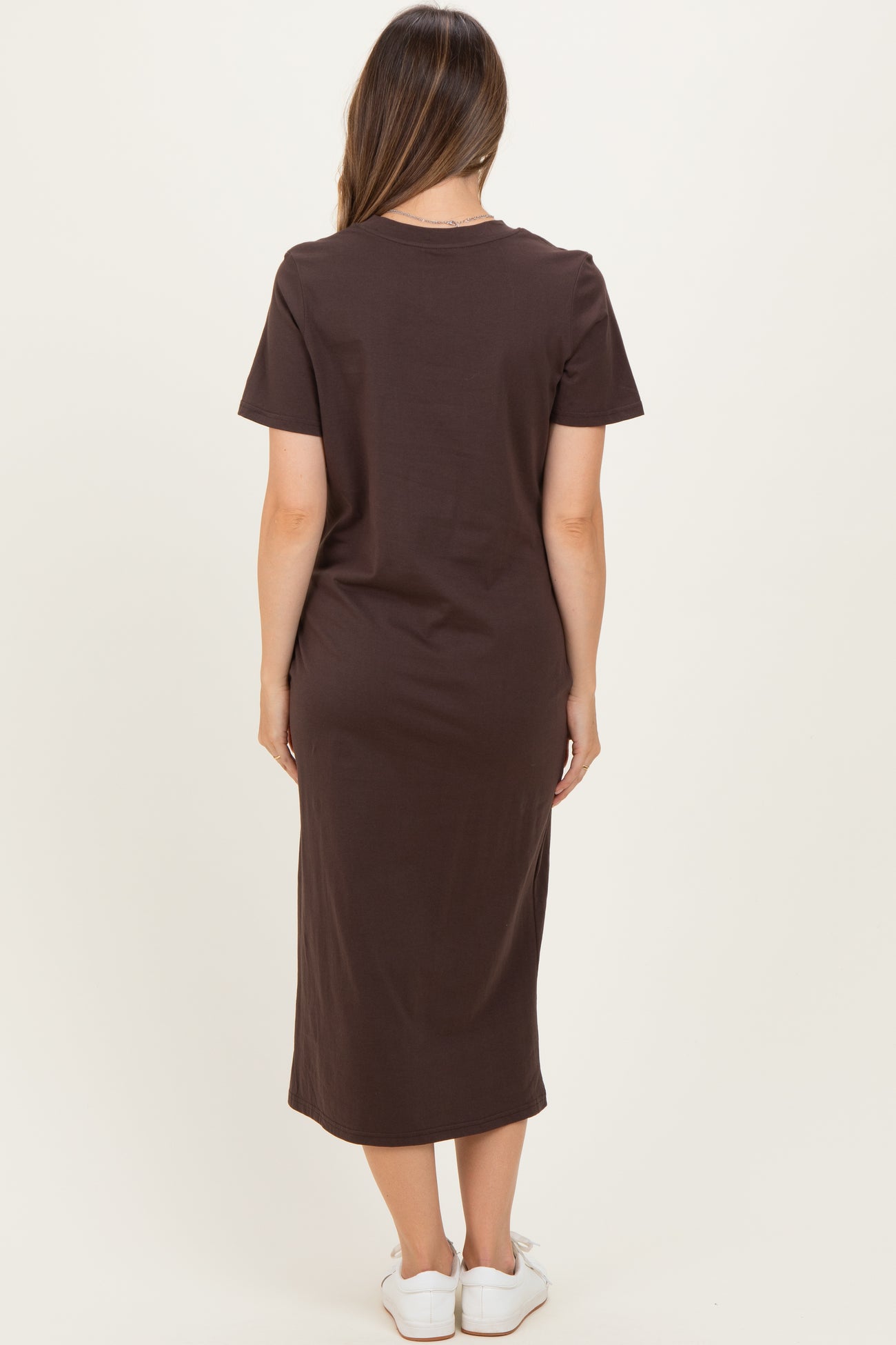 woman wearing a brown short sleeve maternity dress with a midi length, viewed from the back