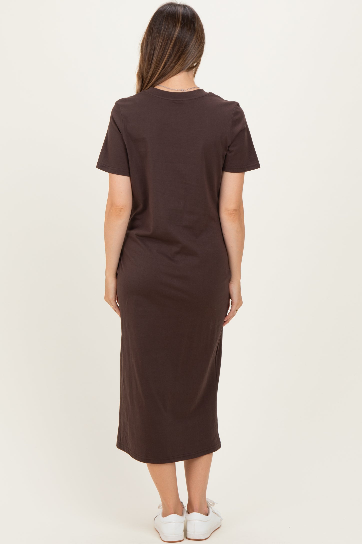 woman wearing a brown short sleeve maternity dress with a midi length, viewed from the back