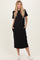 woman wearing a black short sleeve maxi dress with side pockets and white sneakers