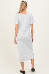 woman wearing a gray short sleeve maternity dress with a side slit, shown from the back