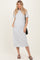 woman wearing a grey short sleeve maxi dress with pockets and holding a black woven bag