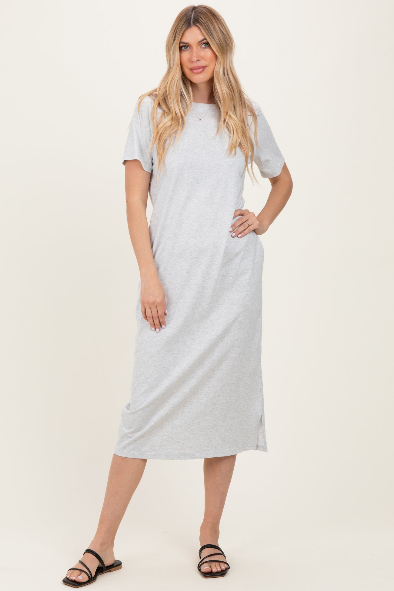 woman wearing a grey short sleeve maxi dress with side slits and black sandals