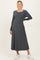 woman wearing a dark gray long sleeve maternity dress with a flowy skirt and a visible baby bump