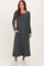 woman wearing a grey long sleeve maxi dress with pockets and white sneakers