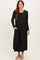 woman wearing a black long sleeve maxi dress with a round neckline and side pockets