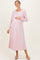 woman wearing a light pink long sleeve maternity dress and holding her baby bump