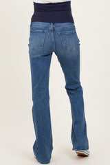 woman wearing a pair of blue bootcut maternity jeans with a high waist and stretchy waistband, showing the back view