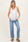 woman wearing a white ribbed maternity tank top and light blue distressed jeans, showing her baby bump