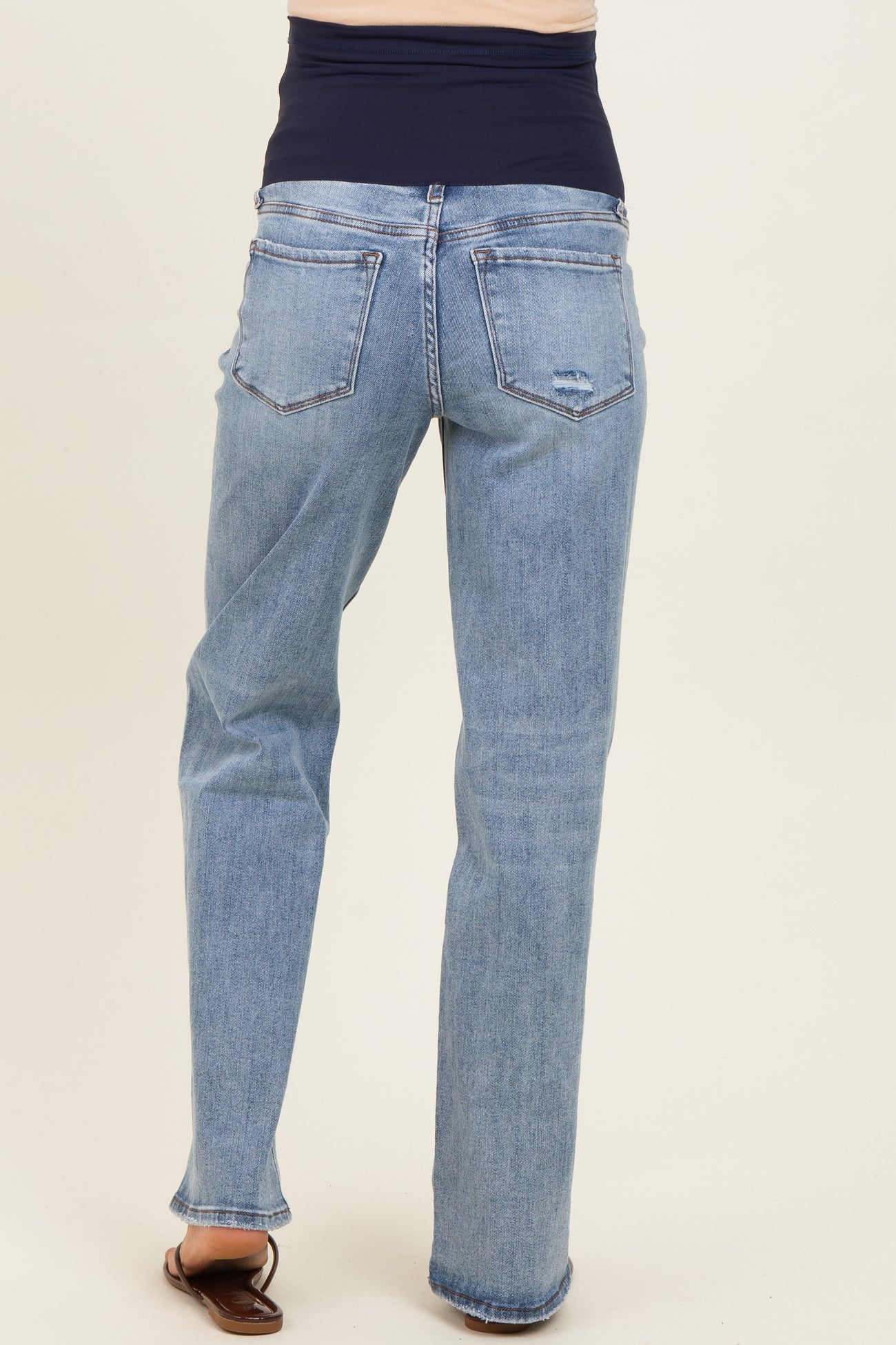woman wearing light blue maternity jeans with a dark blue stretchy waistband, viewed from the back