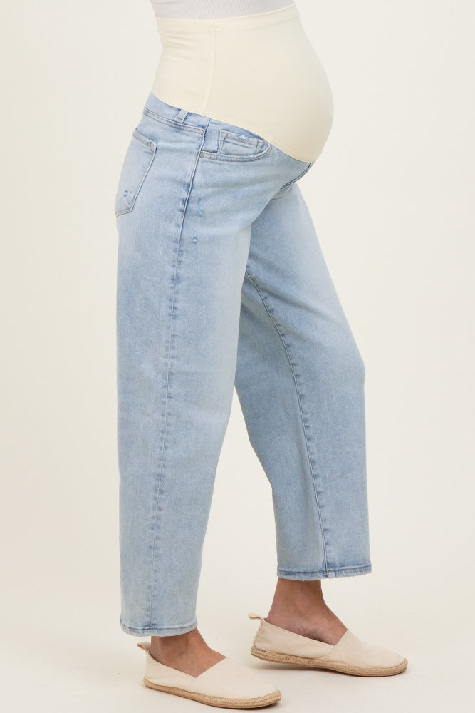 woman wearing light blue maternity jeans with a soft belly panel and a visible baby bump