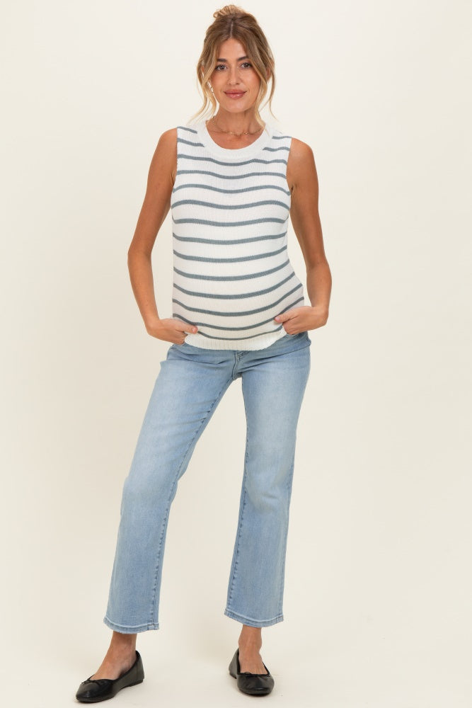 woman wearing a striped maternity tank top and light blue jeans, showing her baby bump