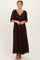 woman wearing a brown maxi dress with a floral print and short puff sleeves