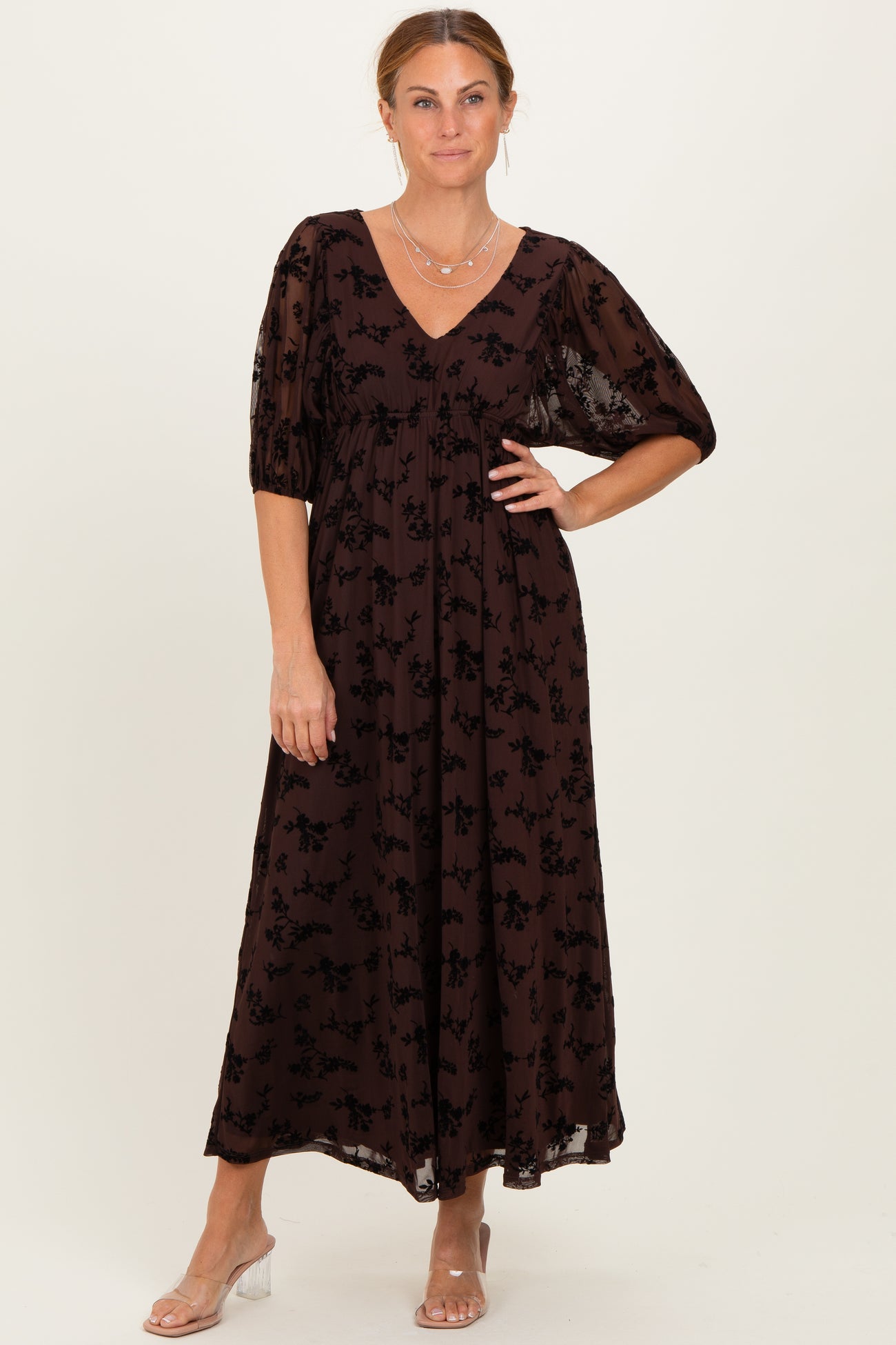 woman wearing a brown floral maxi dress with puff sleeves and a v-neckline