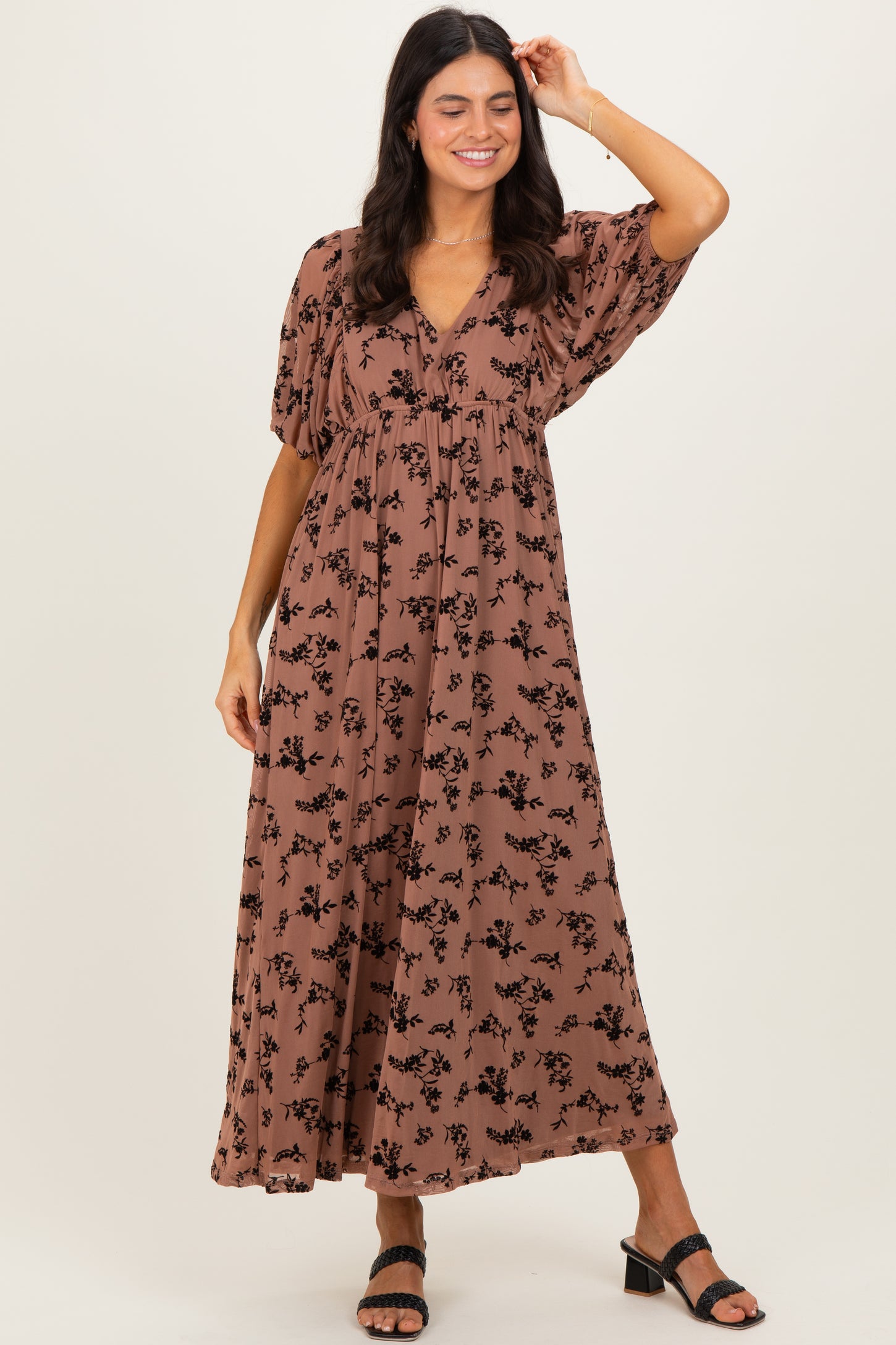 woman wearing a brown floral maxi dress with short sleeves and a v-neckline
