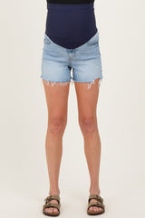woman wearing light blue distressed maternity shorts with a navy belly band