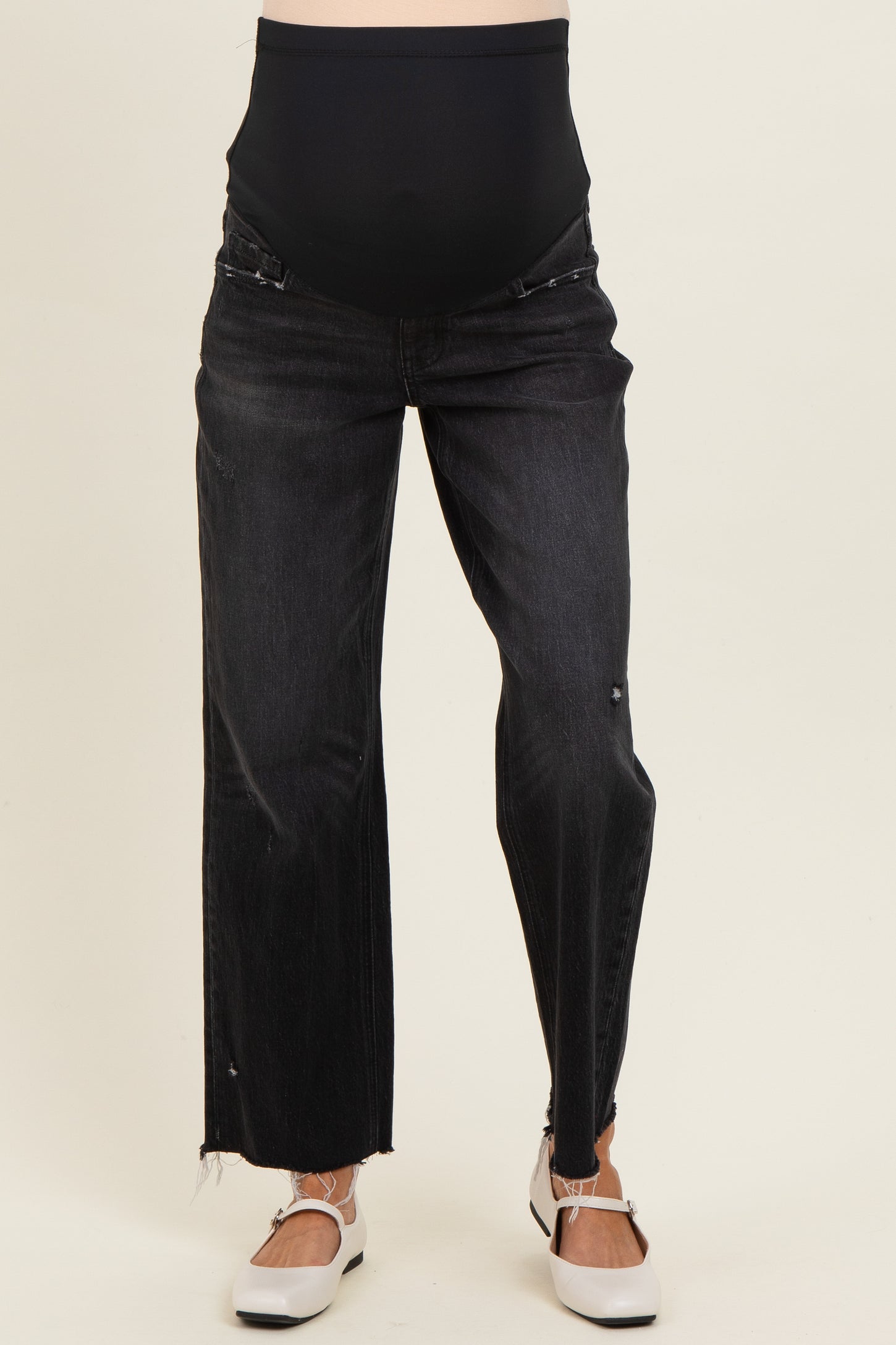 woman wearing black distressed maternity jeans with a supportive belly band