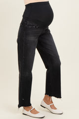 woman wearing black maternity jeans with a stretchy waistband and frayed hem, showing her baby bump